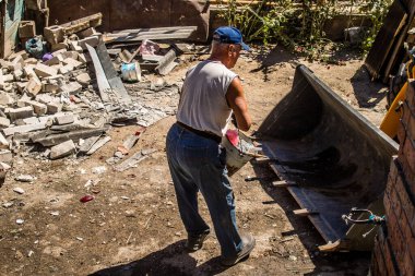 Tsyrkuny, Ukrayna, 29 Haziran 2024 İşçiler Tsyrkuny köyündeki yıkılmış evleri temizleyip onarıyor. Rus kuvvetleri Kharkiv Oblastı 'ndaki Tsyrkuny köyüne güdümlü hava bombasıyla saldırdılar..