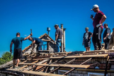 Tsyrkuny, Ukrayna, 29 Haziran 2024 İşçiler Tsyrkuny köyündeki yıkılmış evleri temizleyip onarıyor. Rus kuvvetleri Kharkiv Oblastı 'ndaki Tsyrkuny köyüne güdümlü hava bombasıyla saldırdılar..