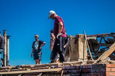 Tsyrkuny, Ukrayna, 29 Haziran 2024 İşçiler Tsyrkuny köyündeki yıkılmış evleri temizleyip onarıyor. Rus kuvvetleri Kharkiv Oblastı 'ndaki Tsyrkuny köyüne güdümlü hava bombasıyla saldırdılar..