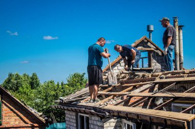 Tsyrkuny, Ukrayna, 29 Haziran 2024 İşçiler Tsyrkuny köyündeki yıkılmış evleri temizleyip onarıyor. Rus kuvvetleri Kharkiv Oblastı 'ndaki Tsyrkuny köyüne güdümlü hava bombasıyla saldırdılar..