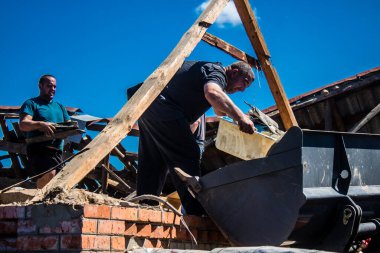 Tsyrkuny, Ukrayna, 29 Haziran 2024 İşçiler Tsyrkuny köyündeki yıkılmış evleri temizleyip onarıyor. Rus kuvvetleri Kharkiv Oblastı 'ndaki Tsyrkuny köyüne güdümlü hava bombasıyla saldırdılar..