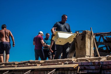 Tsyrkuny, Ukrayna, 29 Haziran 2024 İşçiler Tsyrkuny köyündeki yıkılmış evleri temizleyip onarıyor. Rus kuvvetleri Kharkiv Oblastı 'ndaki Tsyrkuny köyüne güdümlü hava bombasıyla saldırdılar..