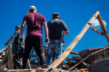 Tsyrkuny, Ukrayna, 29 Haziran 2024 İşçiler Tsyrkuny köyündeki yıkılmış evleri temizleyip onarıyor. Rus kuvvetleri Kharkiv Oblastı 'ndaki Tsyrkuny köyüne güdümlü hava bombasıyla saldırdılar..