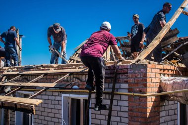 Tsyrkuny, Ukrayna, 29 Haziran 2024 İşçiler Tsyrkuny köyündeki yıkılmış evleri temizleyip onarıyor. Rus kuvvetleri Kharkiv Oblastı 'ndaki Tsyrkuny köyüne güdümlü hava bombasıyla saldırdılar..