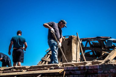 Tsyrkuny, Ukrayna, 29 Haziran 2024 İşçiler Tsyrkuny köyündeki yıkılmış evleri temizleyip onarıyor. Rus kuvvetleri Kharkiv Oblastı 'ndaki Tsyrkuny köyüne güdümlü hava bombasıyla saldırdılar..