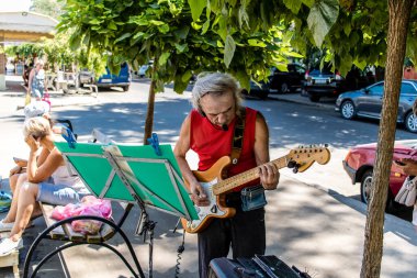 Odessa, Ukrayna, 17 Temmuz 2024. Bir müzisyen, Odessa sokaklarında gitar çalarak para kazanıyor. Ülke Rusya ile savaştayken ve şehre sayısız saldırı düzenlenirken..