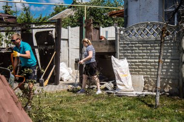 Derhachi, Ukrayna, 27 Haziran 2024 Derhachi kasabasındaki yıkılmış evlerin sakinleri Rus kuvvetlerinin güdümlü hava bombasıyla yaptığı saldırının ardından enkazı temizledi..