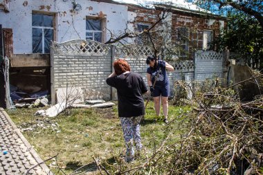 Derhachi, Ukrayna, 27 Haziran 2024 Derhachi kasabasındaki yıkılmış evlerin sakinleri Rus kuvvetlerinin güdümlü hava bombasıyla yaptığı saldırının ardından enkazı temizledi..