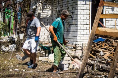Derhachi, Ukrayna, 27 Haziran 2024 Derhachi kasabasındaki yıkılmış evlerin sakinleri Rus kuvvetlerinin güdümlü hava bombasıyla yaptığı saldırının ardından enkazı temizledi..