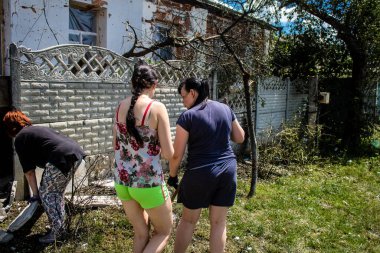 Derhachi, Ukrayna, 27 Haziran 2024 Derhachi kasabasındaki yıkılmış evlerin sakinleri Rus kuvvetlerinin güdümlü hava bombasıyla yaptığı saldırının ardından enkazı temizledi..