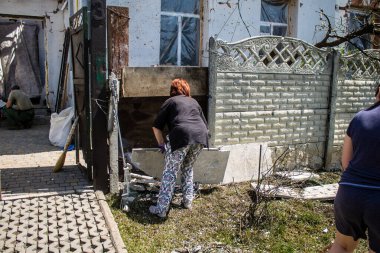 Derhachi, Ukrayna, 27 Haziran 2024 Derhachi kasabasındaki yıkılmış evlerin sakinleri Rus kuvvetlerinin güdümlü hava bombasıyla yaptığı saldırının ardından enkazı temizledi..