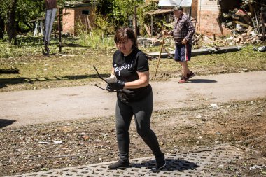 Derhachi, Ukrayna, 27 Haziran 2024 Derhachi kasabasındaki yıkılmış evlerin sakinleri Rus kuvvetlerinin güdümlü hava bombasıyla yaptığı saldırının ardından enkazı temizledi..