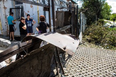 Derhachi, Ukrayna, 27 Haziran 2024 Derhachi kasabasındaki yıkılmış evlerin sakinleri Rus kuvvetlerinin güdümlü hava bombasıyla yaptığı saldırının ardından enkazı temizledi..