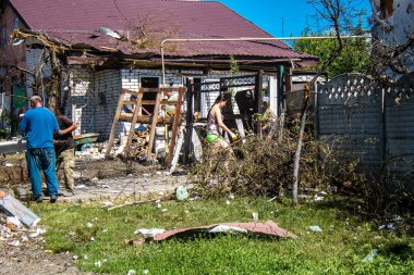 Derhachi, Ukrayna, 27 Haziran 2024 Derhachi kasabasındaki yıkılmış evlerin sakinleri Rus kuvvetlerinin güdümlü hava bombasıyla yaptığı saldırının ardından enkazı temizledi..