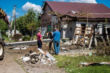 Derhachi, Ukrayna, 27 Haziran 2024 Derhachi kasabasındaki yıkılmış evlerin sakinleri Rus kuvvetlerinin güdümlü hava bombasıyla yaptığı saldırının ardından enkazı temizledi..