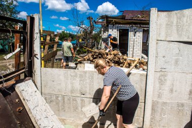 Derhachi, Ukrayna, 27 Haziran 2024 Derhachi kasabasındaki yıkılmış evlerin sakinleri Rus kuvvetlerinin güdümlü hava bombasıyla yaptığı saldırının ardından enkazı temizledi..