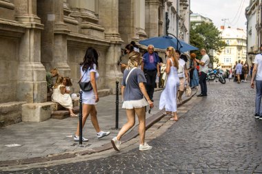Lviv, Ukrayna, 18 Ağustos 2024 Lviv sakinleri ve turistler tarihi şehir merkezinde yürüyorlar. Ülke savaşta olmasına rağmen, çoğu işletme açık ve insanlar normal bir hayat yaşamaya çalışıyor..