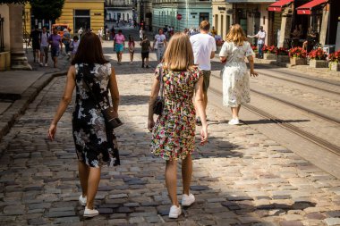 Lviv, Ukrayna, 18 Ağustos 2024 Lviv sakinleri ve turistler tarihi şehir merkezinde yürüyorlar. Ülke savaşta olmasına rağmen, çoğu işletme açık ve insanlar normal bir hayat yaşamaya çalışıyor..