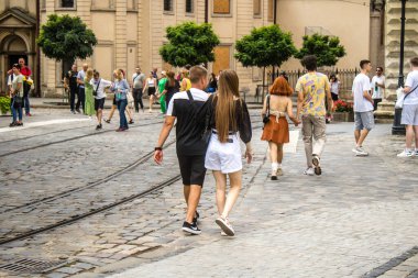 Lviv, Ukrayna, 18 Ağustos 2024 Lviv sakinleri ve turistler tarihi şehir merkezinde yürüyorlar. Ülke savaşta olmasına rağmen, çoğu işletme açık ve insanlar normal bir hayat yaşamaya çalışıyor..