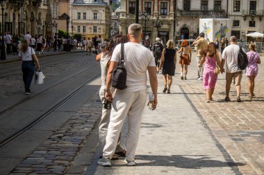 Lviv, Ukrayna, 18 Ağustos 2024 Lviv sakinleri ve turistler tarihi şehir merkezinde yürüyorlar. Ülke savaşta olmasına rağmen, çoğu işletme açık ve insanlar normal bir hayat yaşamaya çalışıyor..