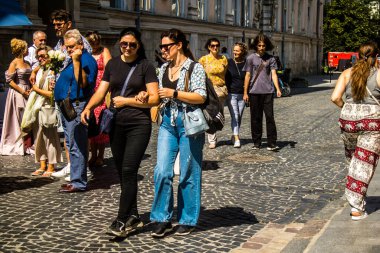 Lviv, Ukrayna, 18 Ağustos 2024 Lviv sakinleri ve turistler tarihi şehir merkezinde yürüyorlar. Ülke savaşta olmasına rağmen, çoğu işletme açık ve insanlar normal bir hayat yaşamaya çalışıyor..