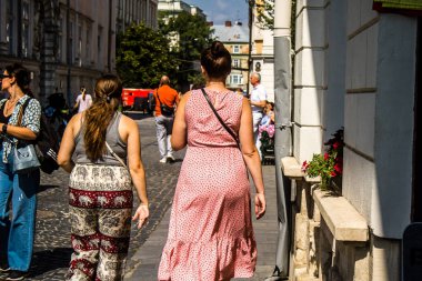 Lviv, Ukrayna, 18 Ağustos 2024 Lviv sakinleri ve turistler tarihi şehir merkezinde yürüyorlar. Ülke savaşta olmasına rağmen, çoğu işletme açık ve insanlar normal bir hayat yaşamaya çalışıyor..