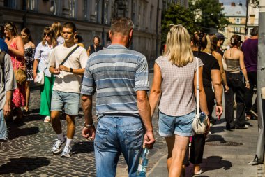 Lviv, Ukrayna, 18 Ağustos 2024 Lviv sakinleri ve turistler tarihi şehir merkezinde yürüyorlar. Ülke savaşta olmasına rağmen, çoğu işletme açık ve insanlar normal bir hayat yaşamaya çalışıyor..