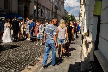 Lviv, Ukrayna, 18 Ağustos 2024 Lviv sakinleri ve turistler tarihi şehir merkezinde yürüyorlar. Ülke savaşta olmasına rağmen, çoğu işletme açık ve insanlar normal bir hayat yaşamaya çalışıyor..