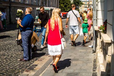 Lviv, Ukrayna, 18 Ağustos 2024 Lviv sakinleri ve turistler tarihi şehir merkezinde yürüyorlar. Ülke savaşta olmasına rağmen, çoğu işletme açık ve insanlar normal bir hayat yaşamaya çalışıyor..