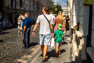 Lviv, Ukrayna, 18 Ağustos 2024 Lviv sakinleri ve turistler tarihi şehir merkezinde yürüyorlar. Ülke savaşta olmasına rağmen, çoğu işletme açık ve insanlar normal bir hayat yaşamaya çalışıyor..