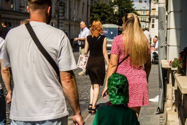 Lviv, Ukrayna, 18 Ağustos 2024 Lviv sakinleri ve turistler tarihi şehir merkezinde yürüyorlar. Ülke savaşta olmasına rağmen, çoğu işletme açık ve insanlar normal bir hayat yaşamaya çalışıyor..