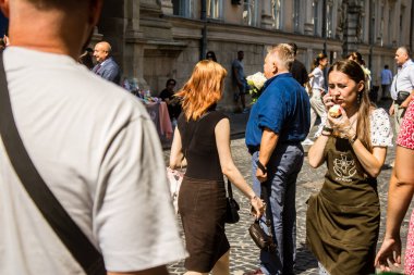 Lviv, Ukrayna, 18 Ağustos 2024 Lviv sakinleri ve turistler tarihi şehir merkezinde yürüyorlar. Ülke savaşta olmasına rağmen, çoğu işletme açık ve insanlar normal bir hayat yaşamaya çalışıyor..