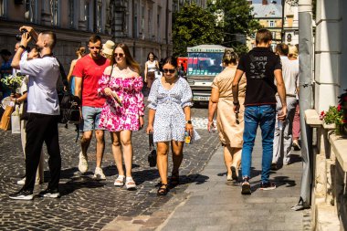Lviv, Ukrayna, 18 Ağustos 2024 Lviv sakinleri ve turistler tarihi şehir merkezinde yürüyorlar. Ülke savaşta olmasına rağmen, çoğu işletme açık ve insanlar normal bir hayat yaşamaya çalışıyor..