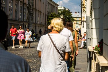 Lviv, Ukrayna, 18 Ağustos 2024 Lviv sakinleri ve turistler tarihi şehir merkezinde yürüyorlar. Ülke savaşta olmasına rağmen, çoğu işletme açık ve insanlar normal bir hayat yaşamaya çalışıyor..