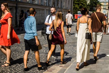 Lviv, Ukrayna, 18 Ağustos 2024 Lviv sakinleri ve turistler tarihi şehir merkezinde yürüyorlar. Ülke savaşta olmasına rağmen, çoğu işletme açık ve insanlar normal bir hayat yaşamaya çalışıyor..