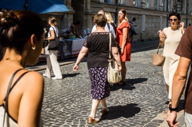 Lviv, Ukrayna, 18 Ağustos 2024 Lviv sakinleri ve turistler tarihi şehir merkezinde yürüyorlar. Ülke savaşta olmasına rağmen, çoğu işletme açık ve insanlar normal bir hayat yaşamaya çalışıyor..