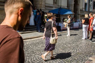 Lviv, Ukrayna, 18 Ağustos 2024 Lviv sakinleri ve turistler tarihi şehir merkezinde yürüyorlar. Ülke savaşta olmasına rağmen, çoğu işletme açık ve insanlar normal bir hayat yaşamaya çalışıyor..