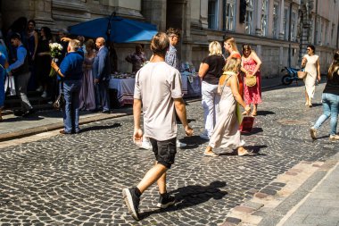 Lviv, Ukrayna, 18 Ağustos 2024 Lviv sakinleri ve turistler tarihi şehir merkezinde yürüyorlar. Ülke savaşta olmasına rağmen, çoğu işletme açık ve insanlar normal bir hayat yaşamaya çalışıyor..