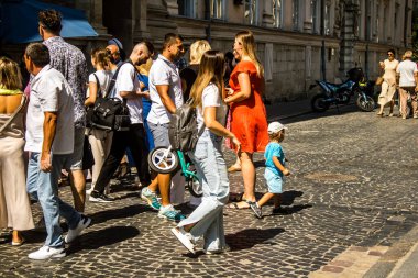 Lviv, Ukrayna, 18 Ağustos 2024 Lviv sakinleri ve turistler tarihi şehir merkezinde yürüyorlar. Ülke savaşta olmasına rağmen, çoğu işletme açık ve insanlar normal bir hayat yaşamaya çalışıyor..