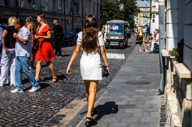 Lviv, Ukrayna, 18 Ağustos 2024 Lviv sakinleri ve turistler tarihi şehir merkezinde yürüyorlar. Ülke savaşta olmasına rağmen, çoğu işletme açık ve insanlar normal bir hayat yaşamaya çalışıyor..