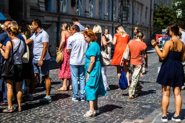 Lviv, Ukrayna, 18 Ağustos 2024 Lviv sakinleri ve turistler tarihi şehir merkezinde yürüyorlar. Ülke savaşta olmasına rağmen, çoğu işletme açık ve insanlar normal bir hayat yaşamaya çalışıyor..