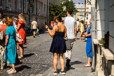 Lviv, Ukrayna, 18 Ağustos 2024 Lviv sakinleri ve turistler tarihi şehir merkezinde yürüyorlar. Ülke savaşta olmasına rağmen, çoğu işletme açık ve insanlar normal bir hayat yaşamaya çalışıyor..