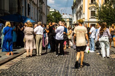 Lviv, Ukrayna, 18 Ağustos 2024 Lviv sakinleri ve turistler tarihi şehir merkezinde yürüyorlar. Ülke savaşta olmasına rağmen, çoğu işletme açık ve insanlar normal bir hayat yaşamaya çalışıyor..