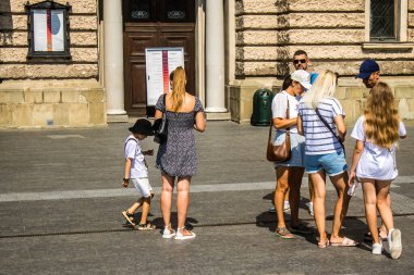 Lviv, Ukrayna, 18 Ağustos 2024 Lviv sakinleri ve turistler tarihi şehir merkezinde yürüyorlar. Ülke savaşta olmasına rağmen, çoğu işletme açık ve insanlar normal bir hayat yaşamaya çalışıyor..