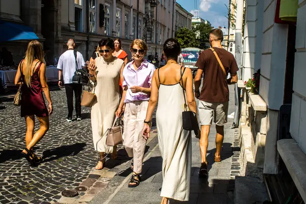 Lviv, Ukrayna, 18 Ağustos 2024 Lviv sakinleri ve turistler tarihi şehir merkezinde yürüyorlar. Ülke savaşta olmasına rağmen, çoğu işletme açık ve insanlar normal bir hayat yaşamaya çalışıyor..