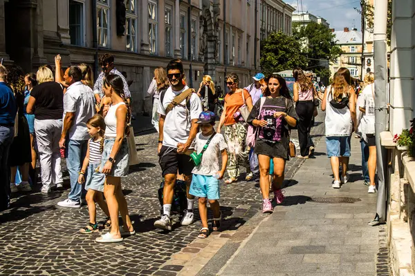 Lviv, Ukrayna, 18 Ağustos 2024 Lviv sakinleri ve turistler tarihi şehir merkezinde yürüyorlar. Ülke savaşta olmasına rağmen, çoğu işletme açık ve insanlar normal bir hayat yaşamaya çalışıyor..