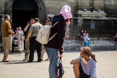 Lviv, Ukrayna, 18 Ağustos 2024 Lviv sakinleri ve turistler tarihi şehir merkezinde yürüyorlar. Ülke savaşta olmasına rağmen, çoğu işletme açık ve insanlar normal bir hayat yaşamaya çalışıyor..