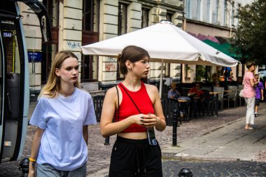 Lviv, Ukrayna, 18 Ağustos 2024 Lviv sakinleri ve turistler tarihi şehir merkezinde yürüyorlar. Ülke savaşta olmasına rağmen, çoğu işletme açık ve insanlar normal bir hayat yaşamaya çalışıyor..