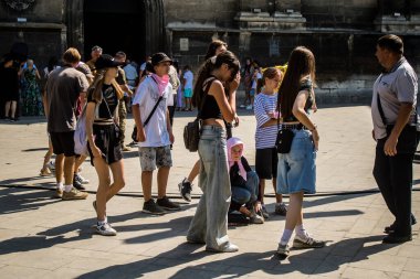 Lviv, Ukrayna, 18 Ağustos 2024 Lviv sakinleri ve turistler tarihi şehir merkezinde yürüyorlar. Ülke savaşta olmasına rağmen, çoğu işletme açık ve insanlar normal bir hayat yaşamaya çalışıyor..