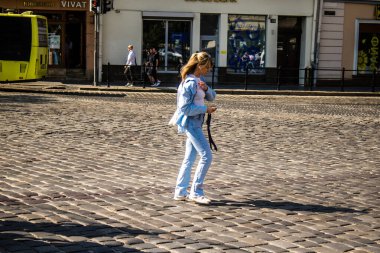 Lviv, Ukrayna, 18 Ağustos 2024 Lviv sakinleri ve turistler tarihi şehir merkezinde yürüyorlar. Ülke savaşta olmasına rağmen, çoğu işletme açık ve insanlar normal bir hayat yaşamaya çalışıyor..